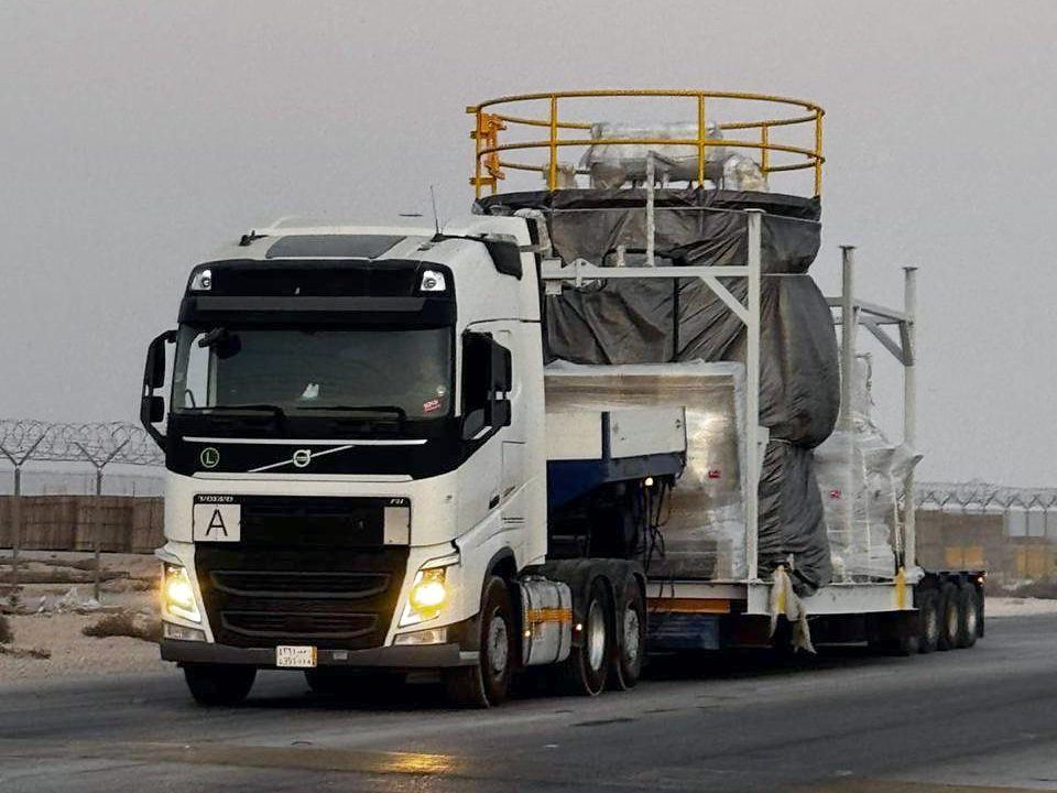 Process skid on a lowbed trailer at dusk