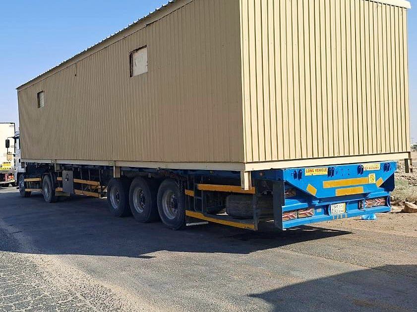 Site cabin loaded on a lowbed trailer